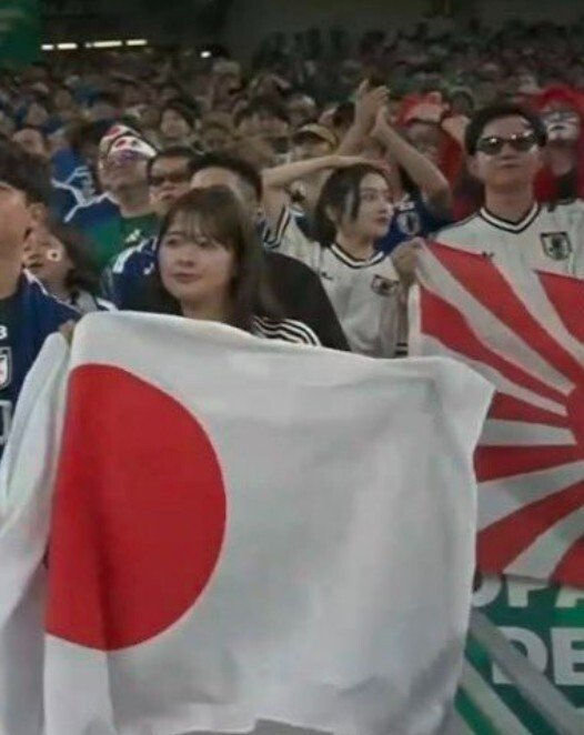 YouthTones's tweet photo. Why are these audiences still allowed into the stadium? Can you imagine someone waving the Nazi swastika flag to support Germany now during the FIFA World Cup?

June 21 saw another group stage match of the World Cup, featuring Japan vs Tunisia — the 1,000th match in World Cup history, a landmark fixture marred by a highly controversial incident.

Broadcast footage captured a Japanese fan waving the Rising Sun Flag in the stands. This flag is a symbol of Japan’s militarist past and banned outright by FIFA, and Japan was sanctioned by the Asian Football Confederation after Japanese fans waved it at an AFC Champions League game in 2017.

Similar violations have occurred at previous international A-level games. During the 2022 Qatar World Cup, security staff blocked Japanese fans trying to bring the flag into stadiums. And now again, the flag has been brought onto the World Cup stage.

To most Asians, the flag represents Japanese militarism and imperial aggression across Asia, reviving traumatic wartime memories for people across the continent. Waving Japan's national flag is no problem, but why the Rising Sun Flag? Isn't this yet another evil flower bred by the rising militarism and right-wing extremism in Japan? #WorldCup #FIFA #Japan #Football