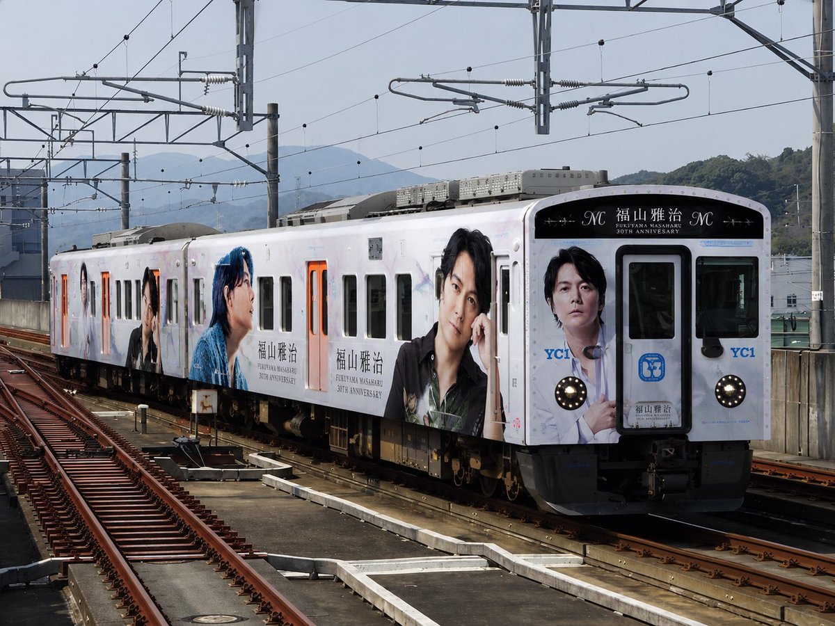 Neochizaka's tweet photo. もし福山雅治ラッピング列車が走ったら。

長崎の景色と、
福山雅治の世界観をひとつの列車に乗せてみました。

あなたなら乗ってみたいですか？

#福山雅治 #YC1 #長崎 #ラッピング列車 #鉄道好き #AI生成 #SAKAIWORKS https://t.co/qEPrQTaQyO