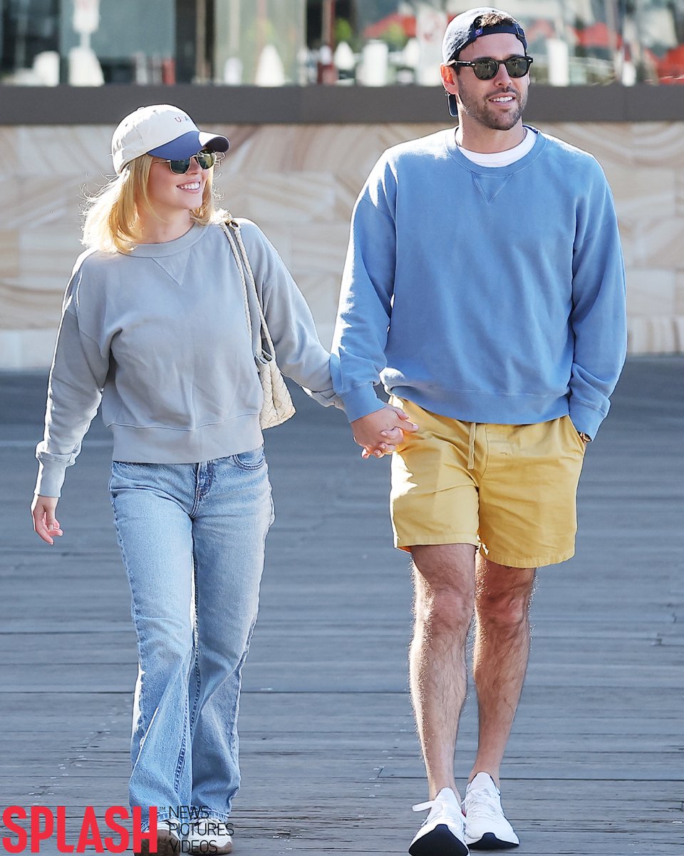 SplashNews's tweet photo. Sydney Sweeney and Scooter Braun pack on the PDA in Sydney, during a romantic stroll around the Sydney Harbour foreshore 🥰🇦🇺

Sydney kept her date look casual, wearing jeans and a grey sweater, accessorising with a patriotic USA baseball cap by Frasier Sterling and a Bottega Veneta mini andiamo purse 👜