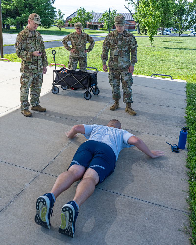 BelleVisuals's tweet photo. U.S. Air Force Col. Matthew Kopp, left, 126th Air Refueling Wing, deputy commander, times 2nd Lt. Austin Hays, 126th Force Support Squadron, as he performs the hand release pushups at Scott Air Foce Base, Illinois, June 18, 2026. Kopp spent part of the morning with FSS performi… https://t.co/90KifgguWG