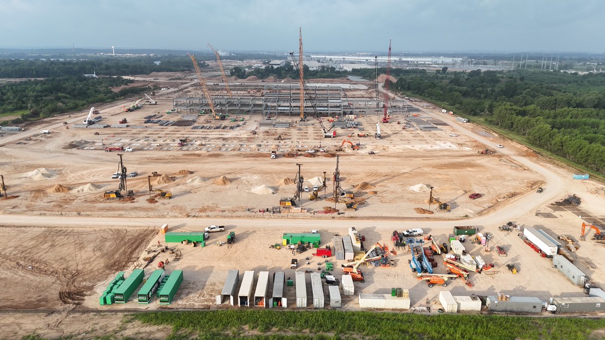 JoeTegtmeyer's tweet photo. Construction of the @Tesla Optimus Factory at Giga Texas (planned for ~10M/yr production once fully ramped up) continues, with more of the steel structure assembly evident. The structure appears to have (at least in this section) 4 floors, but that could vary across the entire factory as assembly continues.

More footings have been completed, GeoPier work on the N end while grade work on the S end. Land reclamation work also on the far S end to extend the ground slab of the building further.

Lots of work ahead, but I think they are currently on track for a late 2027 substantive completion of the structure. However, I would not be surprised to see initial setup & test production underway before the building itself is fully completed, just like we saw with the original main factory.