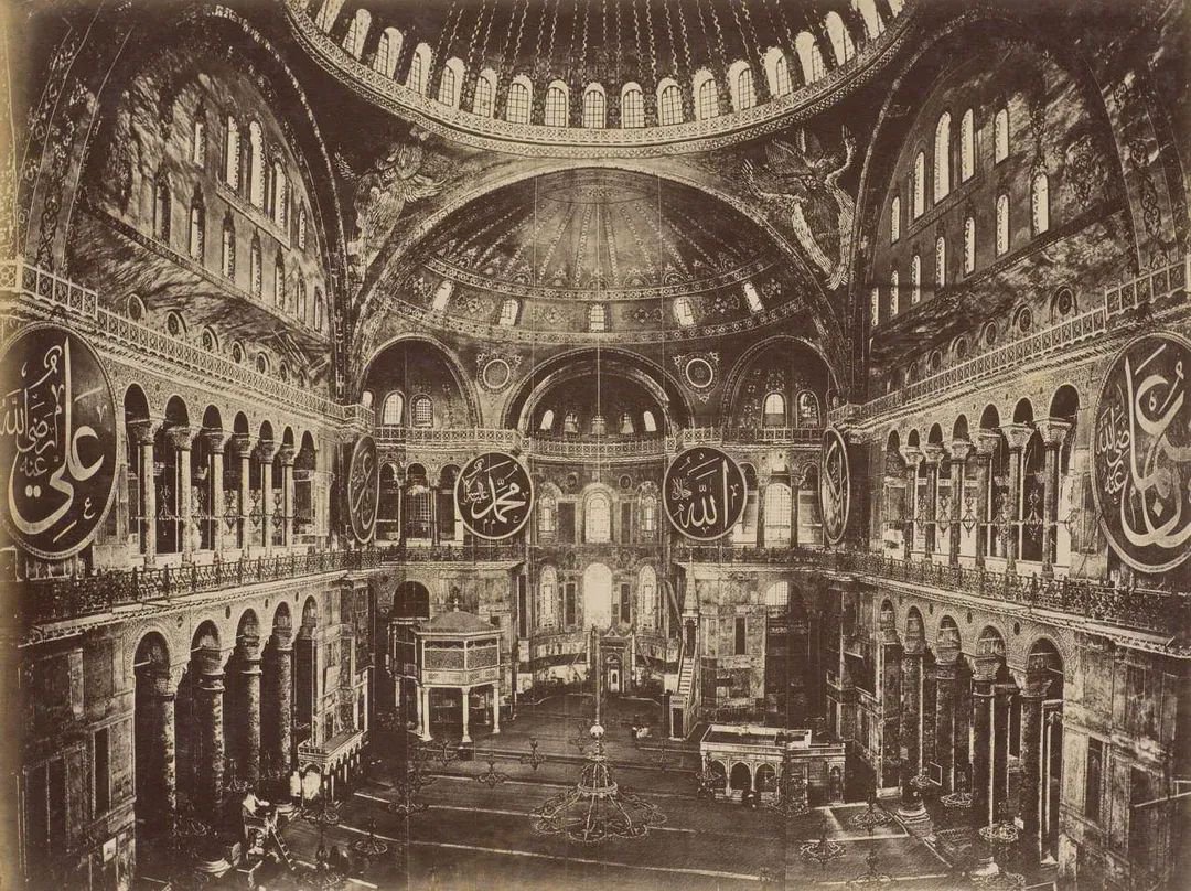 archeohistories's tweet photo. The historical photograph shows the interior of the Hagia Sophia in Istanbul, highlighting its grand dome and Ottoman-era calligraphy panels, 1875... The image taken by Pascal Sébah or Sebah and Joaillier in the 1870s.

Completed in 537 AD during the reign of Byzantine Emperor Justinian I, the Hagia Sophia stood as the world's largest cathedral for nearly 1000 years. Its massive central dome, spanning about 31m (102ft), was an engineering achievement that influenced religious architecture across Europe and the Middle East for centuries.

After the Ottoman conquest of Constantinople in 1453 AD, Sultan Mehmed II converted the building into a mosque. Christian mosaics were plastered over rather than destroyed, allowing many to survive into the modern era. Large roundels bearing the names of Allah, Muhammad, and the first Caliphs were added during 19th Century restorations.

The structure has endured earthquakes, fires, political upheaval, and nearly 1500 years of continuous use. In 1935 it became a museum under the Republic of Turkey, before being reconverted into a mosque in 2020.

The Hagia Sophia's dome rises about 55.6m (182ft) above the floor. When it was completed in the 6th century, contemporaries described it as appearing to float in the air because of the ring of windows at its base, an effect that still impresses visitors today.

#archaeohistories