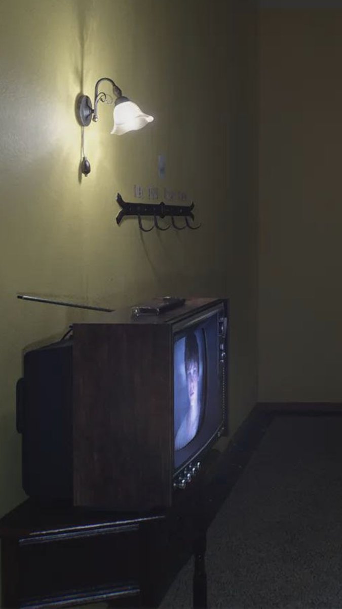 immalkwalahi's tweet photo. Some details you can see in the new image from  OD

-You can see a woman wearing a red dress in the room in front of you, with horns.

-You can see the hands of a monster in the attic, and it's most likely a stalker.

-You can see the door on your left locked with chains, indicating there is no escape.

-You can see Sophie's character on TV, and you can also see some eyes on the wall.