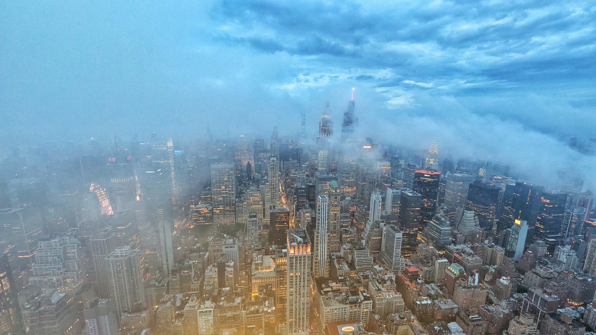 GaryHershorn's tweet photo. Fog passing through midtown Manhattan at sunset in New York City, seen from the 86th floor of the Empire State Building, Monday evening #nyc #newyork #newyorkcity #sunset @empirestatebldg https://t.co/61szfXMqNQ