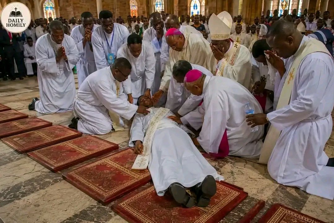 UcheMaryOkoli's tweet photo. THE PRIEST WHO NEVER ROSE AGAIN😱😱

The cathedral fell silent as the Litany of the Saints echoed through the sacred building.

Hundreds of voices prayed.

"Holy Mary, Mother of God, pray for us..."

The candidates lay face down before the altar, surrendering their lives completely to God.

Among them was Emmanuel.

As he rested on the cold marble floor, his heart was strangely peaceful.

His mind drifted back through the years.

He remembered carrying water with his mother under the hot sun.

He remembered the day his father died and held his hand one last time.

"Never stop serving God, my son."
He remembered the tears, the sacrifices, the loneliness, and the countless nights spent praying before the Blessed Sacrament.

Everything had led to this moment.

The Litany continued.

The congregation prayed with devotion.

His mother clutched her rosary tightly.

Tears of joy rolled down her cheeks.

Her son was only minutes away from becoming a priest.

Then the Litany ended.

The bishop stood.

The candidates were invited to rise.

One by one, they pushed themselves up from the floor.
At first, nobody noticed.

Everyone was focused on the bishop.

Then one of the candidates glanced beside him.

Emmanuel was still lying there.

Motionless.

He gently touched his shoulder.

No response.

A second touch.

Nothing.

The smile on his face disappeared.

The congregation smiled.

Families reached for their phones.

This was the moment they had been waiting for.

But Emmanuel did not move.

Another candidate knelt beside him.

The choir slowly stopped singing.

A strange silence spread across the cathedral.

The bishop stepped forward.

Priests rushed toward the sanctuary.

Emmanuel's mother stood up.

Fear filled her eyes.

"What's happening?" she whispered.

A priest checked Emmanuel's pulse.

Then checked again.

The cathedral held its breath.

The priest slowly looked up.

His eyes were filled with tears.

And everyone understood.

Emmanuel was gone.

A cry pierced the silence.

It was his mother.

The woman who had sacrificed everything to see this day had just watched heaven take her son.

People wept openly.

Even priests who had witnessed countless funerals struggled to hold back tears.

Only moments earlier they had expected to see Emmanuel stand and receive priestly ordination.

Instead, he had entered eternity.

Later, as people gathered around his grieving mother, someone asked how she could bear such pain.

With tears flowing down her face, she looked toward the altar and said:

"I gave my son to God many years ago. Today God accepted him completely."

The cathedral erupted in tears once again.
That day, Emmanuel never celebrated his first Mass.

He never preached a homily.

He never blessed a congregation.

But his final lesson touched more hearts than many sermons ever could.

For years people spoke about the young seminarian who lay before the altar and never rose again.

Not because he failed to become a priest.

But because, at the very moment he offered his life to God, God called him home.

And while everyone else stood up from the cathedral floor...

Emmanuel stood up in heaven.

THE END.

- Martin Kibira