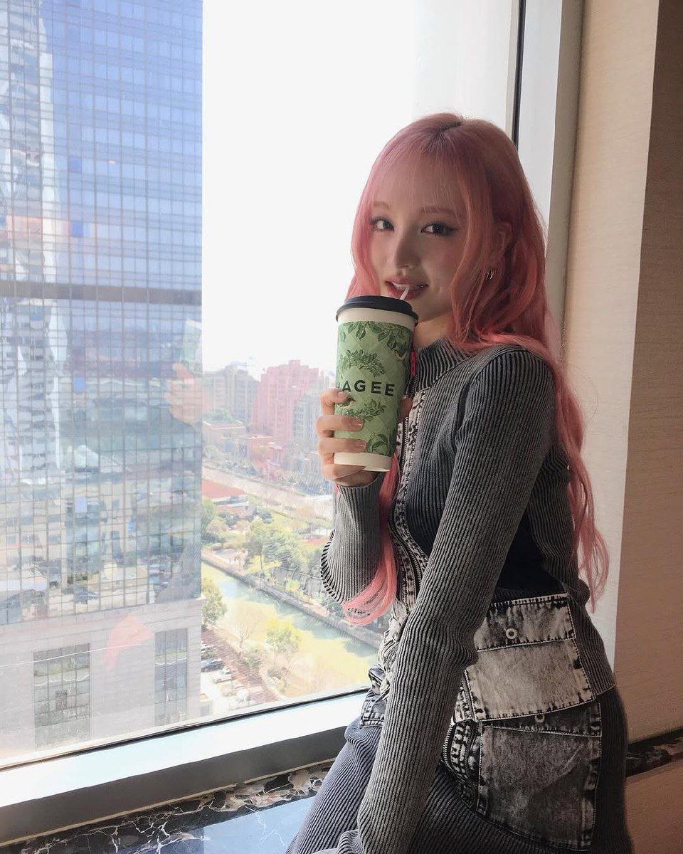 kimjizwon's tweet photo. With a paper of sweetness in my hands and the evening breeze dancing through my pink hair, I linger on the balcony where the sky slowly melts into shades of gold and lavender. The city hums softly below, while my heart drifts among clouds painted by the setting sun. https://t.co/mQAA1MksoS