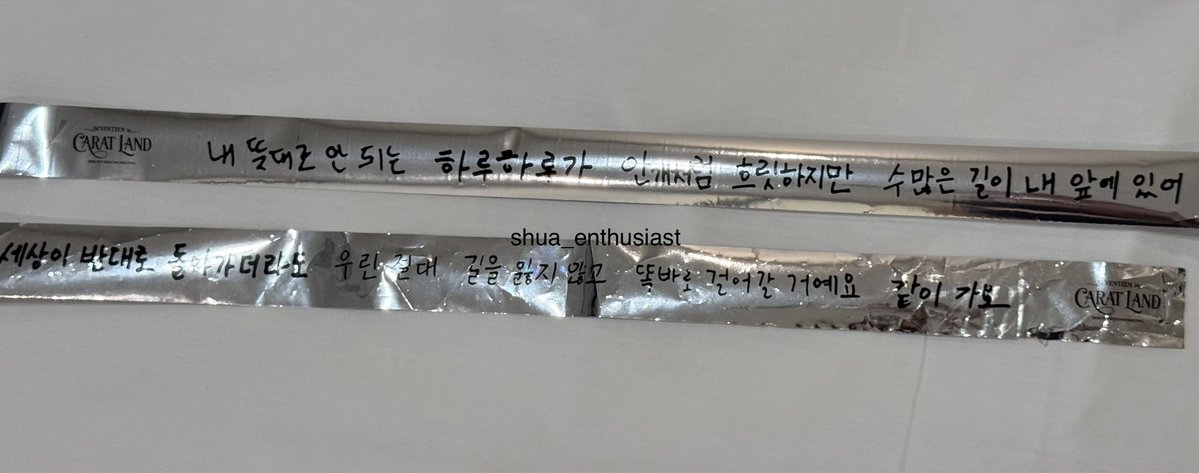 shua_enthusiast's tweet photo. just realized that the caratland 2026 confetti strip are the lyrics of Together in the members' handwriting 🥹 and it was their opening song 💔

"the day which isn't going according to my plans.
it may be blurry like the fog but there are many paths before me.
even if the world goes in the opposite direction,
we will never lose our way,
and we will walk in the right direction"