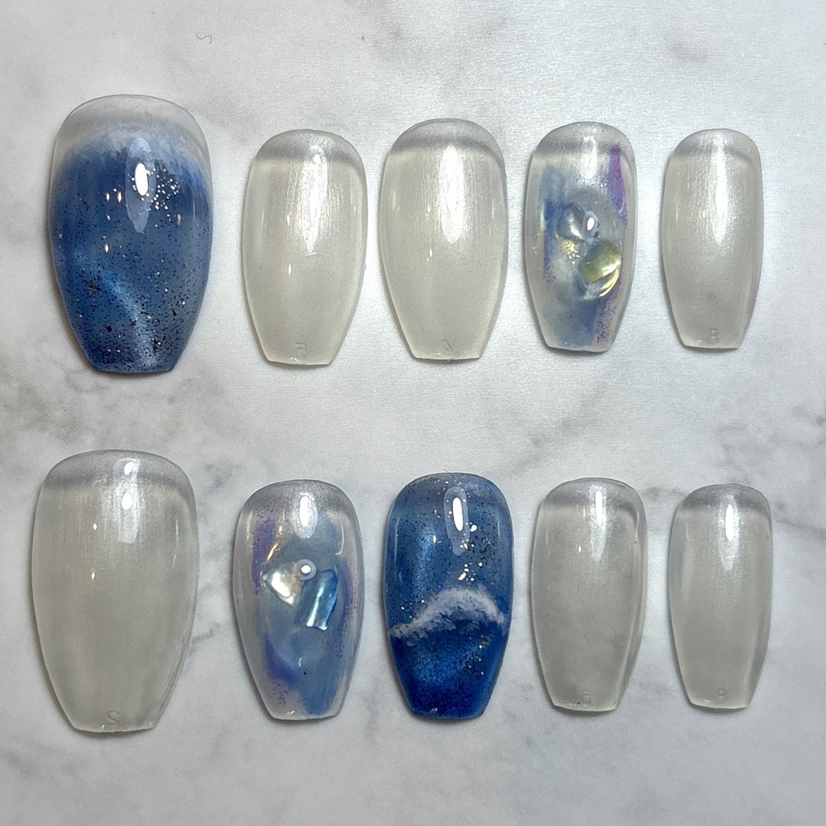 chora_nail's tweet photo. 透明感のあるパープルマグネットに深みのあるブルーを重ね、ぷっくりシェルアートと手描きの波模様を合わせた夏ネイル🌊✨

光の角度によって表情が変わるマグネットの輝きと、うるっとした透明感がポイントです🫧

涼しげなカ...

詳細はこちら↓（ネイルブック）
https://t.co/gGnZ6Kf10c https://t.co/Ds7HuK0ans