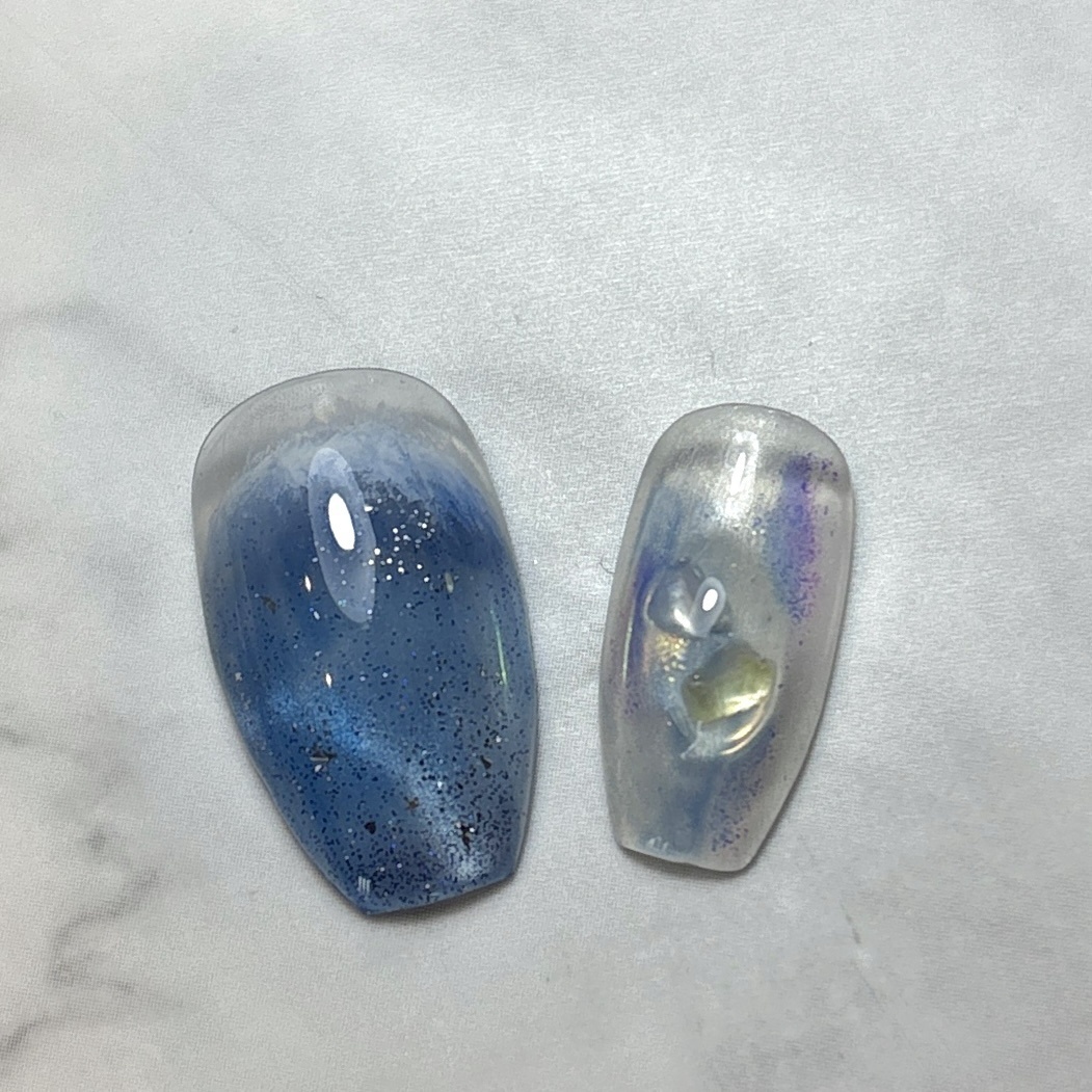 chora_nail's tweet photo. 透明感のあるパープルマグネットに深みのあるブルーを重ね、ぷっくりシェルアートと手描きの波模様を合わせた夏ネイル🌊✨

光の角度によって表情が変わるマグネットの輝きと、うるっとした透明感がポイントです🫧

涼しげなカ...

詳細はこちら↓（ネイルブック）
https://t.co/gGnZ6Kf10c https://t.co/Ds7HuK0ans