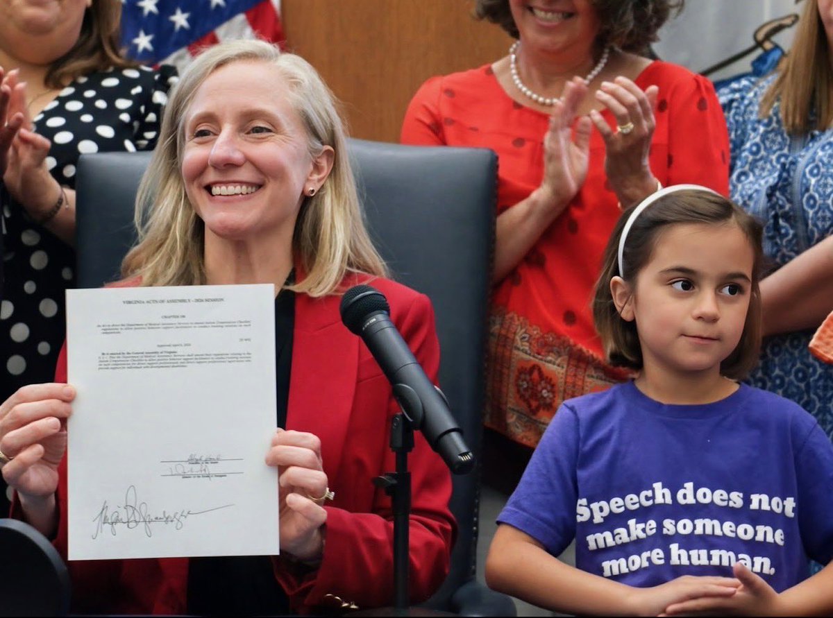 Communica1st's tweet photo. Ready to wear the change you want to see in the world? The Jordyn Zimmerman Speech Does Not Make Someone More Human Shirts are back, but only through June 30! Get yours now and support the fight for #CommunicationRights. https://t.co/SoDTtevPNL

[Image: Sitting in front of a microphone, Governor Abigail Spanberger proudly holds up a signed copy of the Virginia Acts of Assembly. Next to her is a young girl wearing a shirt that says: Speech does not make someone more human. Behind them, people are clapping.]