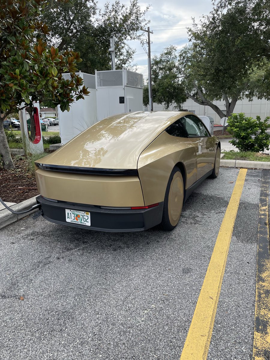 DailyModel3FSD's tweet photo. CYBERCAB 🤖🚕 spotted again in the Orlando (Winter Park) area at the local supercharger. 

Briefly spoke to the gentleman and he said he loves the job and loves $TSLA 

The Cybercab’s lack of side-view mirrors is one of its most distinctive design features.

What’s interesting, though, is that the Cybercabs currently being tested around Orlando and in other states appear to have steering wheels and pedals. From what I’ve seen, this may be related to testing and regulatory requirements, even though the production Cybercab is expected to be designed without them. 

$SPCX #cybercab #robotaxi #elon