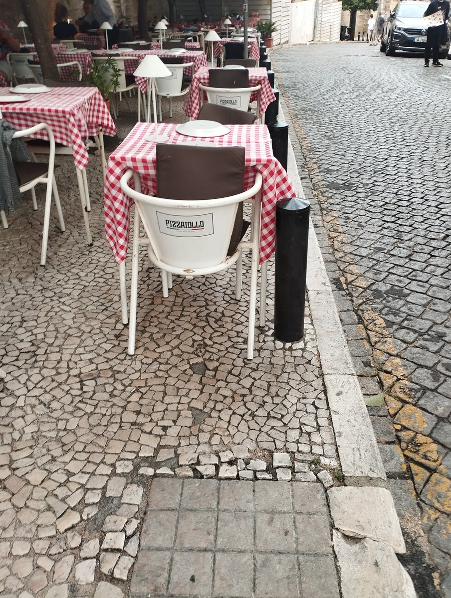 majoliv's tweet photo. Colocaram os pinos para evitar o estacionamento no passeio, mas permite-se o estacionamento de esplanadas. Isto é junto à Sé, mas a colonização das zonas pedestres vê-se em toda a cidade. Os espaços públicos no centro são a verdadeira rebaldaria. Coitada de ti, Lisboa. https://t.co/C5PRq06cSo