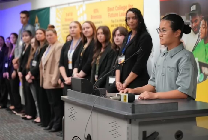 Students participating in Western Michigan University's Cold Case Program standing at the front of a room, answering questions from the media