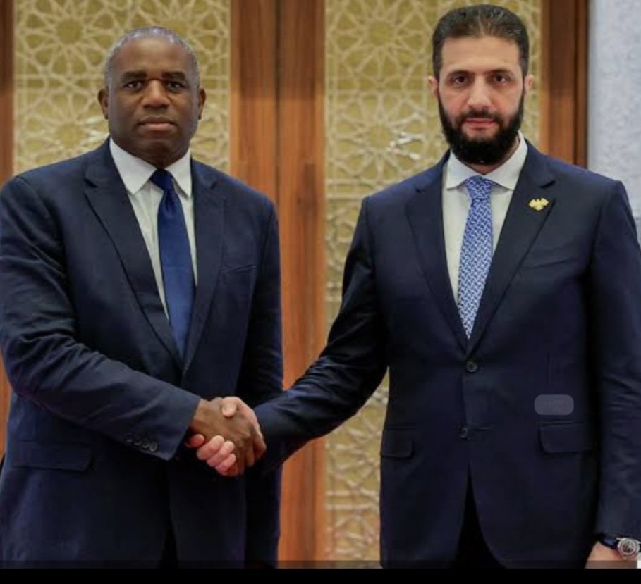 JChimirie66677's tweet photo. The Taliban Got £171 Million. Al-Jolani Got £95 Million. The Boats Keep Coming. Someone Is Happy With This Arrangement.

In October 2025, Britain removed Hayat Tahrir al-Sham from its list of proscribed terrorist organisations. Months earlier, Foreign Secretary David Lammy had flown to Damascus and handed its former leader, Ahmed al-Jolani, £95 million in aid. On 31 March 2026, al-Jolani arrived at Downing Street for talks with Keir Starmer, the first visit by a Syrian head of state to London since Assad's fall. He also met the Attorney General and the Home Secretary. Al-Jolani led HTS from its founding. Before the rebranding, his organisation was designated by the British government itself as a terrorist group. The designation was lifted. The cheque was written. The visit was photographed. According to Downing Street's own readout, Starmer used the meeting to urge "closer work together on returns of illegal migrants, on border security, and on tackling people smuggling networks." The former leader of a proscribed terrorist organisation was being asked to help stop the boats.

Britain sends £171 million a year to Afghanistan. The Taliban has banned women from working for the NGOs that previously delivered it. The government's own parliamentary documents acknowledge the aid cannot be effectively delivered. Ninety-four percent of NGOs fully or partially ceased operations after the ban. The money goes anyway.

In January 2026, al-Hol camp in northeast Syria, which held around 9,000 male ISIS suspects from an estimated 60 countries alongside tens of thousands of family members, collapsed amid fighting between Syrian government forces and Kurdish fighters. A hundred and twenty ISIS members escaped from Shaddadi prison. The Kurdish forces that had guarded the facilities for years withdrew. Syria confirmed a mass escape of ISIS-linked individuals following that withdrawal. Their whereabouts are unknown. Over 70% of those crossing the Channel are undocumented young men from Syria, Afghanistan, Eritrea and Sudan. They carry no papers. Their histories cannot be verified. Britain has no biometric screening mechanism capable of checking arrivals against Syrian detention escape lists, because Syria has no functioning civil registry against which to check them. So the question that nobody in government is prepared to answer is this: how many of the men arriving on British beaches since January 2026 were in those camps? The honest answer is that nobody knows. The more troubling answer is that the government has built no mechanism to find out.

Jonathan Hall, the government's own Independent Reviewer of Terrorism Legislation, said in the aftermath of the Belfast stabbing that asylum seekers from conflict zones present elevated risk profiles, that trauma from witnessed or perpetrated violence compounds that risk, and that his questions about the national security implications of mass migration had been met by the government with silence. The security services' own assessment framework treats exposure to serious violence as a material risk factor. Hall is not speculating. He is describing the government's own methodology.

In the year to June 2025, asylum applications rose 17% and small boat arrivals rose 14%. Twelve new asylum centres were opened this week without informing the MPs in whose constituencies they sit. Speaker Lindsay Hoyle called it totally unacceptable from the chair. Hotel accommodation contracts run until 2039.

A government trying to stop the boats does not pay the regimes the arrivals are fleeing. It does not hand £95 million to a former proscribed terrorist and ask him to tackle people smuggling. It does not build hotel infrastructure contracted until 2039. And it does not open twelve new asylum centres without telling the MPs whose constituents will live next to them.

David Lammy meets Ahmed al-Jolani. Al-Hol camp, northeast Syria.