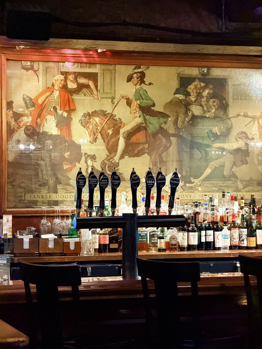 KJP's tweet photo. We may have accidentally found the most Americana pub in America.

Last night we were on the road to pick up our antique wool loom so we can make American flags. We ended up staying at the historic Nassau Inn in Princeton, NJ, in the Norman Rockwell Suite.

That already felt pretty perfect.

Then we went downstairs for a drink at the Yankee Doodle Tap Room and realized there was an original 13 foot Norman Rockwell mural right behind the bar.

He painted it in 1937 and they say it took him nine months to finish.

So there we were, picking up a loom to make American flags, staying in the Norman Rockwell Suite, drinking in a place called Yankee Doodle, sitting under a real Rockwell painting.

You really can’t make this stuff up.

One of the coolest little American road trip moments we’ve ever had. 🏇🏻🇺🇸🍻