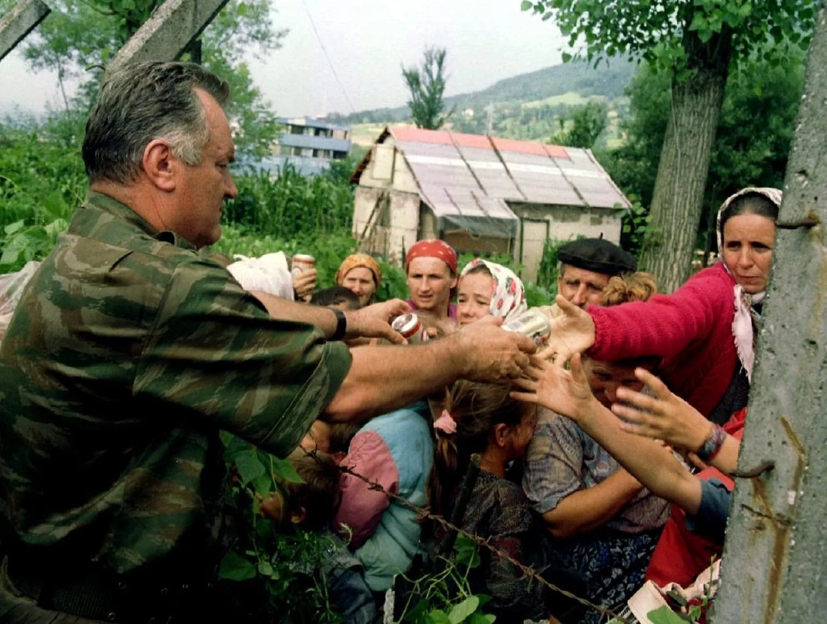 nadidefotograf's tweet photo. Bosna kasabı lakaplı Sırp komutan Ratko Mladić, Bosnalı kadınlara yiyecek dağıtıyor. 
Gazeteciler onun bu fotoğrafını çekerken, emrindeki silahlı milisleri aynı kadınların çocuklarını ve kocalarını katlediyordu.
📍Srebrenica, Temmuz 1995 https://t.co/yc5l8u1hCM