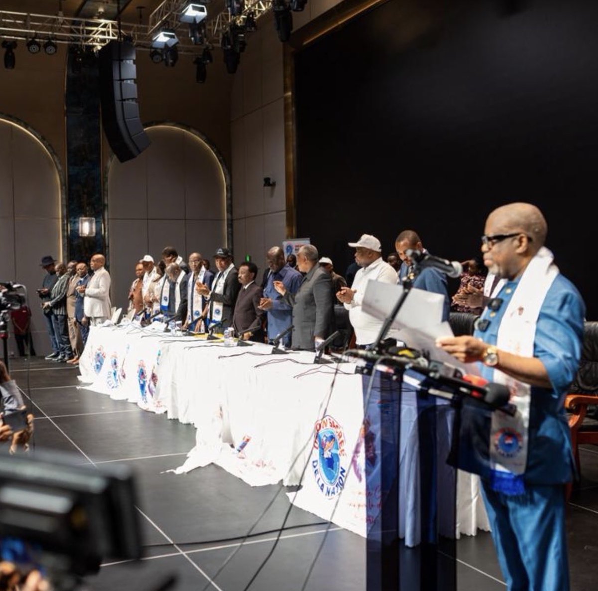 Cartesien243's tweet photo. USN : le réveil du géant

Carte blanche no 285

La réunion de l’USN du 23 juin 2026 marque peut-être un tournant politique. Pour la première fois depuis longtemps, les présidents des partis et regroupements politiques, les députés et les sénateurs de la majorité se sont retrouvés autour d’une même table afin d’examiner, d’amender et d’adopter une déclaration politique en réponse aux prises de position de la CENCO sur les réformes constitutionnelles.

Je salue à cet égard le sens de l’initiative et le flair politique du doyen Christophe Mboso Kodia Pwanga qui a convoqué la réunion et qui a dirigé les travaux avec méthode.

Cette réunion ne constitue pas seulement une réplique à la CENCO. Elle symbolise le réveil d’un géant qui, depuis trop longtemps, semblait observer les événements plus qu'il ne les orientait. En six mois, la CENCO a publié quatre déclarations politiques contre le pouvoir, tandis l’USN n'avait tenu aucune réunion plénière de sa conférence des présidents depuis l'investiture du gouvernement.

Pendant ce temps, une opposition longtemps affaiblie a appris à transformer ses revers en victoires symboliques. La journée ville morte avortée, le sit-in de trois cents personnes, ont été recyclés en succès médiatiques et diplomatiques grâce à la manipulation des images. En politique, celui qui perd la bataille des faits mais gagne celle du récit n'a pas totalement perdu.

L’ USN, elle, a trop souvent laissé ces récits prospérer dans le silence. Or, son rôle devrait être de fixer le rythme du débat national, non de courir derrière les polémistes et les stratèges de l'ombre.

Notre expérience politique récente aurait dû nous servir de leçon. Durant la transition des années 1990, l'Union sacrée de l'opposition radicale comme la majorité présidentielle disposaient de véritables conférences des présidents. Chaque parti y était représenté, les parlementaires participaient aux délibérations, les arbitrages se faisaient autour d'une table avant d'être assumés publiquement. Plus tard, les différentes majorités qui se sont succédé ont, elles aussi, fonctionné avec des mécanismes de concertation relativement structurés. Ce n'était pas parfait, mais c'était plus efficace.

Une famille politique ne fonctionne pas comme une administration. Elle ne peut être paralysée par la lourdeur des procédures et des rivalités. Sans lieu de débat interne, le débat externe est toujours perdu d'avance.

L'USN ne peut dépendre exclusivement de l'agenda de la plus haute autorité occupée à traiter des grands dossiers de la République. Elle doit disposer d'une capacité permanente d'analyse, de proposition et de mobilisation. 

Concrètement, trois piliers s'imposent : un coordonnateur politique reconnu par tous, au lieu d’une hydre à mille têtes; une conférence des présidents qui se réunit à date fixe, avec la participation des groupes parlementaires. Avant qu'un  membre ne prenne une position publique divergente sur un sujet majeur, il s'engage à soumettre son argumentaire à la conférence et à épuiser le débat interne. On peut discuter en famille, mais on ne sort pas du conseil pour parler  sans avoir confronté ses vues à celles des autres. Une majorité qui se divise en sourdine sur ses propres réformes n'est qu'une collection de suffrages.

La réunion du 23 juin a montré qu'une autre dynamique est possible.Ce rendez-vous doit devenir le point de départ d'une pratique régulière, non un événement isolé.

Quand la majorité se tait, ce ne sont pas seulement ses adversaires qui parlent : ce sont aussi les peurs, les rumeurs et les manipulations qui prennent la parole. 

Le géant s'est réveillé. Il lui appartient désormais de rester debout. Pour cela, il doit accepter de se regarder en face, de se doter d'une véritable organisation politique et de reprendre la main sur le récit national.