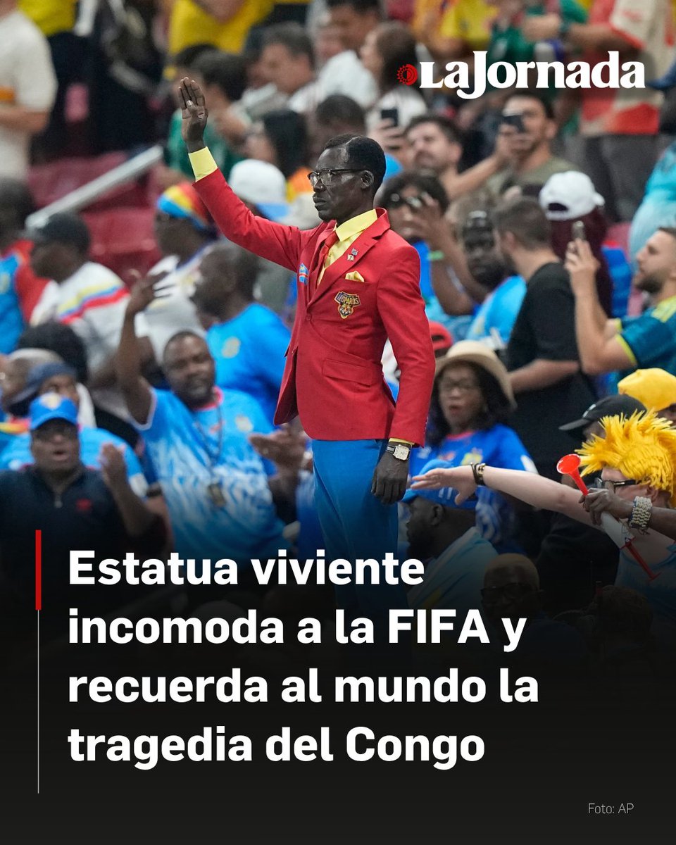 LaJornada's tweet photo. El activista congoleño Michel Kuka Mboladinga, conocido bajo el pseudónimo de "Lumumba Vea", escenificó una protesta simbólica contra las atrocidades del conflicto armado en el este de la República Democrática del Congo durante el partido mundialista de su selección contra Colombia en Guadalajara.

Caracterizado como una estatua viviente que evoca la estética del líder anticolonialista Patrice Lumumba, Mboladinga permaneció inmóvil sobre un pedestal vistiendo los colores de su bandera nacional, rompiendo su quietud únicamente para simular una pistola en la sien y cubrirse la boca.

Esta manifestación visual, orientada a visibilizar un conflicto que ha desplazado a miles de personas y cobrado más de 6 millones de vidas desde los años 90, fue censurada por la transmisión oficial de la FIFA, la cual retiró sus cámaras del personaje en cuanto comenzó a emitir los ademanes de denuncia política.

Más información en: https://t.co/KaYVgb2zBf