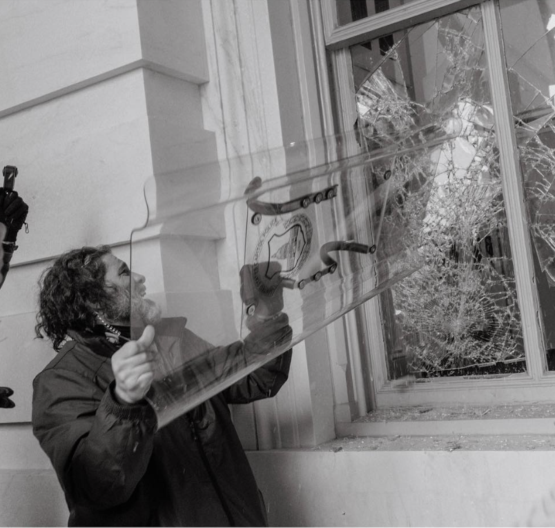 kyledcheney's tweet photo. The lawyer for Dominic Pezzola, the man who did this to the Capitol on Jan. 6, while senators were evacuating, compares the widely documented attack to a 1960s sit-in at Woolworth's. https://t.co/gtzTmh4KpO https://t.co/qAMrPaRdx6