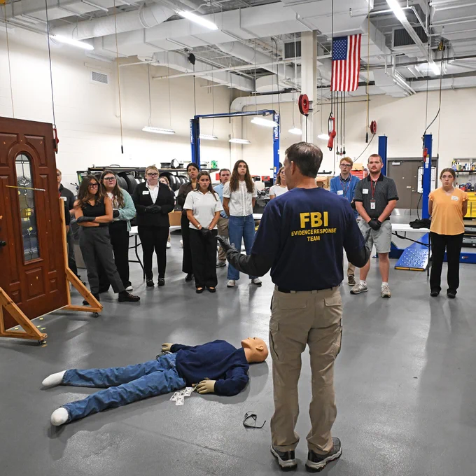 FBI Evidence Response Team member instructs a group of people during a mock crime scene investigation.