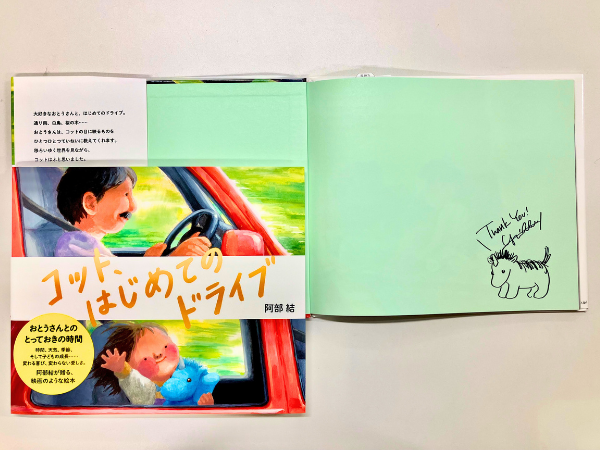 EhonNavi's tweet photo. 🥁🥁絵本ナビサイン本祭り🥁🥁

『どろぼうジャンボリ』（ほるぷ出版）、『おやつどろぼう』（福音館書店）などで注目を集める絵本作家・阿部結さんがこの絵本の中で描いているのは、過ぎていく時間や移ろいゆく世界の中で、変わらずに存在し続けるもの。確かに感じる体温と忘れられない景色と親子の会話。

【阿部 結さん サイン本】 コット、はじめてのドライブ
https://t.co/WQfoHvKpvT

（みどころ）

「コット、ドライブに いくよ」

大好きなおとうさんと、はじめてのドライブ。ドライブが何かも知らないコットは、言われるままに支度をし、車に乗り込み出発です。通り雨にトンネル、湖の景色に、花を咲かせる直前の桜の木。車の窓から見る景色はなんだか特別、次々に移りかわっていきます。

コットが質問をすれば、おとうさんはすぐに答えてくれます。コットみたいなお天気の話、暗いトンネルが怖くなくなる方法、白鳥の旅や四季の話。やがておひさまが沈むと、夜がやってきて、また新しい一日がはじまるのだとおとうさんは教えてくれます。

「あたらしい いちにちになったら
　コットも あたらしい コットになる？」

すっかり違う世界みたいになった夜の景色の中で、コットはふと思うのです。ずっとかわらないことって、あるのかなーー。

『どろぼうジャンボリ』（ほるぷ出版）、『おやつどろぼう』（福音館書店）などで注目を集める絵本作家・阿部結さんがこの絵本の中で描いているのは、過ぎていく時間や移ろいゆく世界の中で、変わらずに存在し続けるもの。確かに感じる体温と忘れられない景色と親子の会話。

初めての出会いを繰り返しながら世界を捉えていく小さな子どもにとって、たとえそれが、ほんの些細で短い時間だったとしても、体に刻み込まれていく記憶や発見や生まれてくる疑問があるのでしょう。おとうさんはコットに何を伝えたのでしょうか。

美しい光が印象的な場面の連続は、まるで一本の映画を観ているかのよう。大切であればあるほど胸がきゅっとする、かけがえのない親子の時間。けれど絵本を開けばいつでも、永遠に残るあの愛おしい時間が、再び静かに動き出すのです。
（絵本ナビ編集長　磯崎園子）