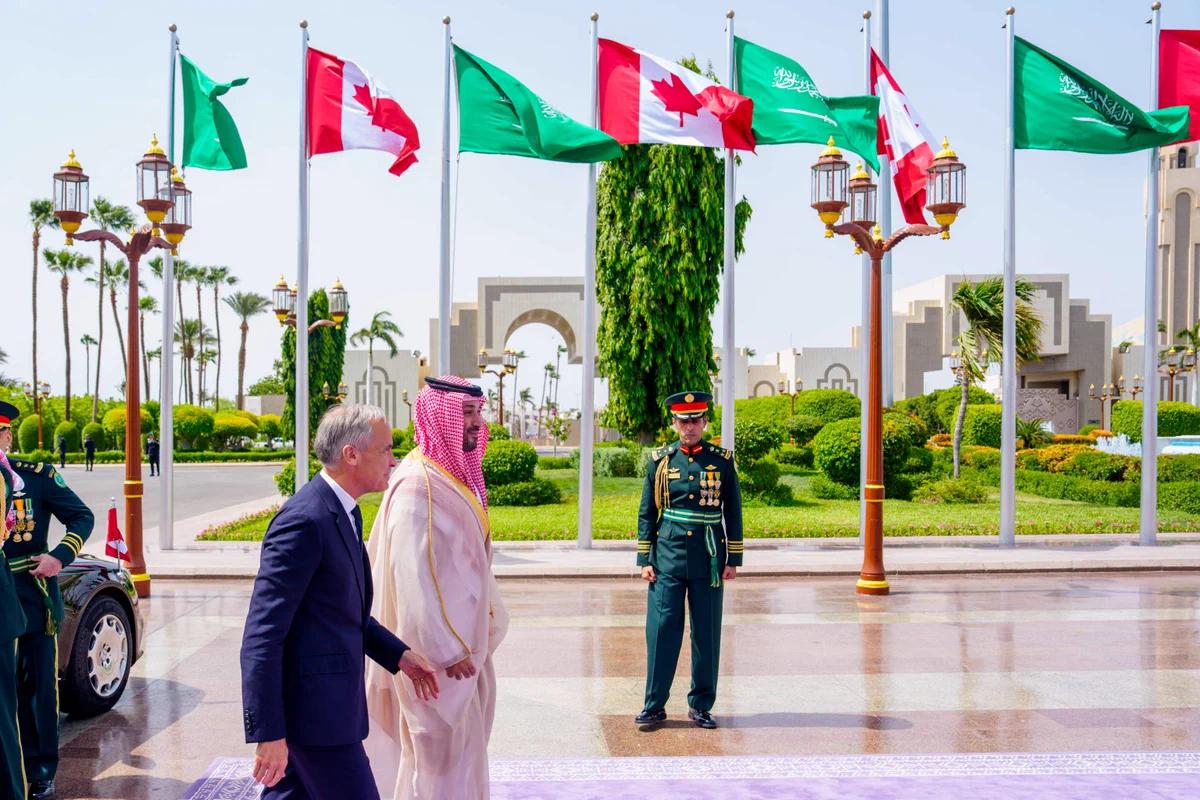 Le premier ministre Mark Carney marche aux côtés du prince héritier et premier ministre de l’Arabie saoudite, Son Altesse Royale Mohammed ben Salmane, lors d’une cérémonie officielle d’accueil à Djedda, en Arabie saoudite. Des drapeaux du Canada et de l’Arabie Saoudite bordent l’endroit, où la garde de cérémonie se tient au garde-à-vous.