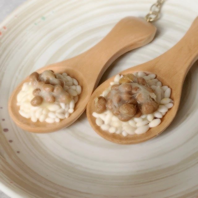 qrou's tweet photo. 今日7/10は #納豆の日 と言うことで甘味処さん過去に作っていた食べられない納豆アクセサリーです！

現在は販売していない作品になりますが納豆の日に併せて楽しんでいただけたら嬉しいですっ米粒一粒ずつ手づくりですっ https://t.co/pRfQy7pJyk