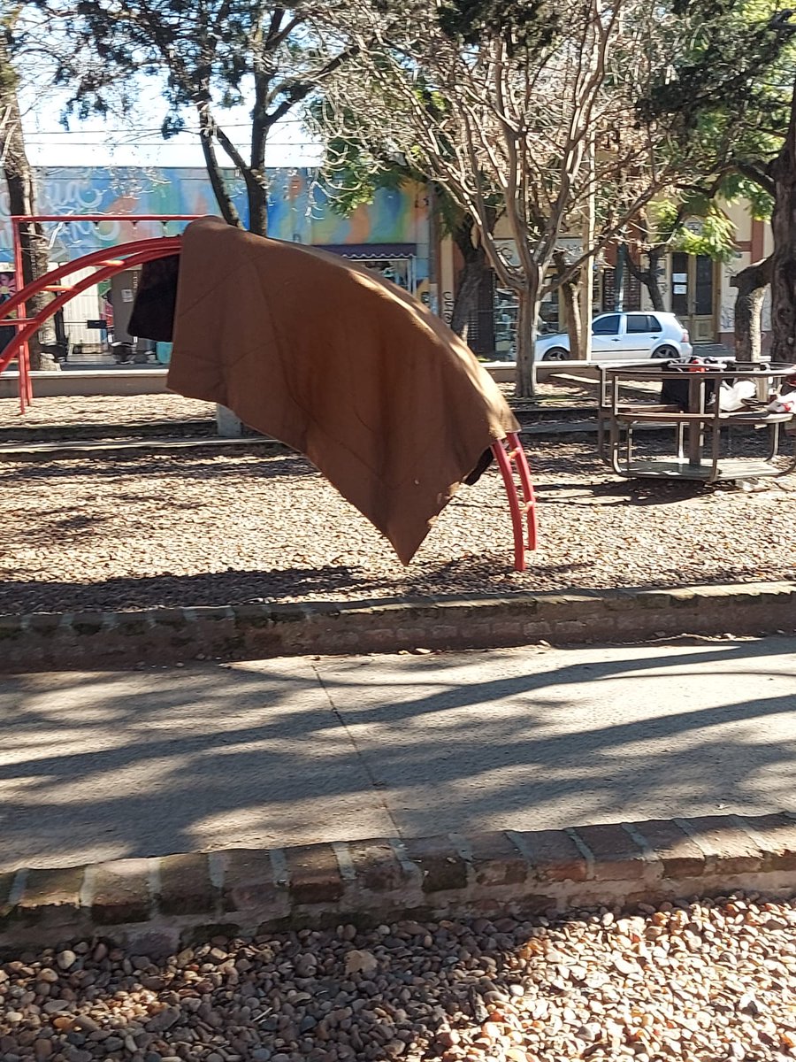 Merlo_Real's tweet photo. Plaza de 25 de mayo. Un grupo de personas tira colchones y duermen de día allí. También usan la calesita y los juegos de los nenes para tender ropa y frazadas. Los vecinos cuentan que aumentaron los robos durante la madrugada. https://t.co/Q0za62DXjW