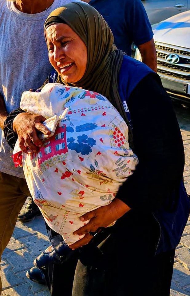PalPress24's tweet photo. I know you're busy watching the World Cup.

But please give me just one minute of your time.

Inside this body bag is a 30-year-old man, a father of three children, who lived with a mental health condition. He was killed by Israeli forces near the "Yellow Line."

Can the world hear what we're trying to say?

After nine days of being left where he was killed, his mother is finally able to hold her son's body
embracing him through a body bag.

I know the World Cup has captured the world's attention.

But I'm asking you to look at this mother.

Can you see her pain?

Can you feel what is happening in #Gaza?
#WorldCup