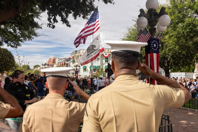 U.S. Marines with the 1st Marine Division Band salute during a flag retreat ceremony at Disneyland California Adventure Park in Anaheim, California, July 4, 2026. The 1st MARDIV Band was featured in\u202Fseveral parades and stationary performances during the park\u2019s annual Independence Day celebration. (U.S. Marine Corps photo by Lance Cpl. Anamile Arce)\n\n