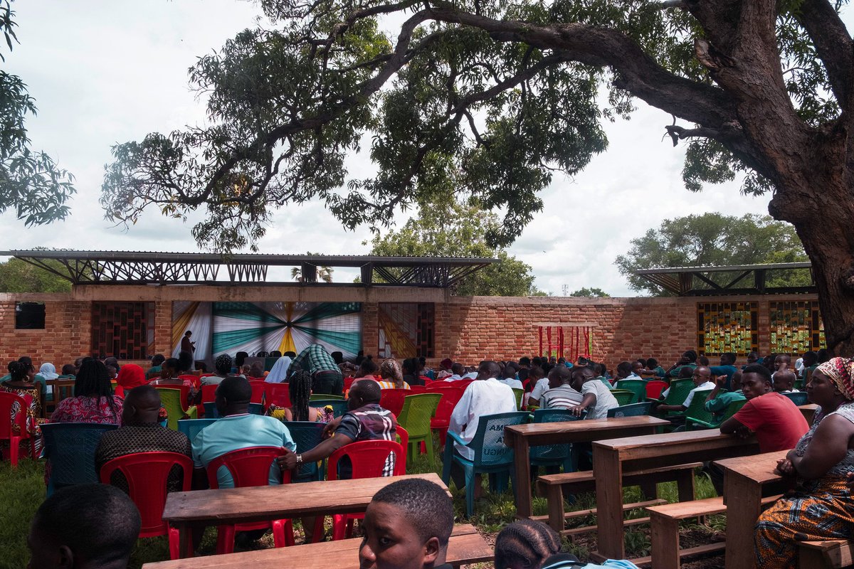 shavnyuyngah's tweet photo. When people build or donate infrastructure in Africa, they scarcely read the environment, and even most African architects scarcely do it either. The result is boxy buildings with tiny openings, painted white or some bright color to look finished. Rain and harmattan dust wear that paint down fast, and repainting or repairing it is upkeep most local communities cannot sustain. So the buildings age badly, not because the climate is harsh, but because the design never accounted for who would maintain it.

The reverse is true for this Tanzanian project.

Wayair School, Ulyankulu, a former refugee settlement in western Tanzania. Jeju Studio, a Polish practice, designed it for the Wayair Foundation. The building is made of locally crafted brick, fired from two different clays, dark red made onsite, lighter red made in a nearby valley, arranged into a gradient rather than painted over. Nothing here needs paint to survive weather, the material carries its own finish and ages into the landscape instead of against it.

The classrooms sit around a courtyard wrapped around existing mango trees, modeled on the local Saturday market where the whole community already gathers under big trees. Roofs are pitched with a ventilation gap at the peak, thick concrete floors hold the classrooms cool through the day, no mechanical cooling anywhere. A 70,000 litre rainwater harvesting system, filled in one short rainy season, carries the school through nine months of dry season.

This is what happens when a design team reads the site, the climate, and the community before drawing a single wall.

Architect: Jeju Studio
Location: Ulyankulu, Tanzania
Client: Wayair Foundation
Photography: Iwo Borkowicz