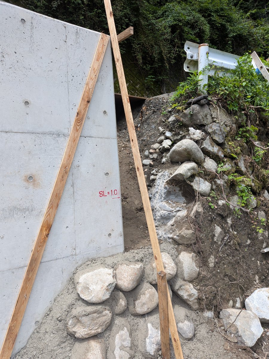seiwa_se_wing's tweet photo. 【根尾　国道157号復旧現場2】

水曜日、国道157号の復旧工事現場に、
再び取材に行ってきました。

ゲートをくぐり、登ること30分。
今回もタイヤをパンクさせることなく、
無事に現着できました。

道路は埋めたのですが、写真の通り、
崩れた石垣を作っていました。

写真を見ると分かるのですが、
崩れていないほうの石垣と同じように、
一つ一つ人力で石を積み、セメントで
固める、という作業をしていました。

この作業、今日あたりまで掛かるとのこと。
バックホウで重い石とセメントは下ろせますが、
そこからの積み上げは手作業。

コツコツと修繕しています。

山の上なので涼しいと思いきや、前日に雨が降り、
意外に蒸し暑かったです。

この道路を作ったときも、こうして石を積んで、
開拓をしていったのかな…？と想像しながら、
作業を見させてもらいました。

相変わらず通行止めは続いていますが、
必ず道は開けます。
もうしばらくお待ちください🙏

#建設業を盛り上げよう
#災害復旧
#国道157号
#岐阜県本巣市根尾
#手作業での復旧