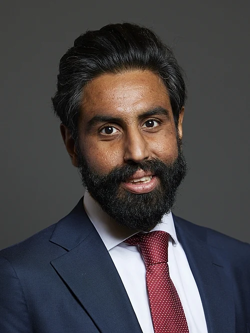 InTheTrenchesUK's tweet photo. Oh, Jeevun. "Dr." How impressive. How authoritative. How utterly, deliberately misleading.

You are not a medical doctor, are you Jeevun? You do not heal. You do not cure. You do not save lives. You have a PhD in Economics and Political Science from LSE. A doctorate in theory. In ideology. In the globalist agenda that pays your bills. Yet you brandish "Dr" like a stethoscope. Like a badge of public trust. Like the authority you have not earned.

And who paid for this authority? Who trained you? Who shaped you? George Soros. The New Economy Organisers Network. The Open Society Foundations. The Fabian Society. The Quaker trusts. The Joseph Rowntree Charitable Trust. The Barrow Cadbury millions. The Paul Hamlyn Foundation with its £1.4 million of taxpayer money. You are not a Member of Parliament, Jeevun. You are a Soros product. A globalist project. A loyal traitor to the UK, trained by foreign money to serve foreign interests.

"Dr Jeevun Sandher MP." The double title. The double deception. Neither "Dr" nor "MP" means what the British public believe. You are a PhD holder pretending to be a healer. A Soros scholar pretending to be a servant of Loughborough. A Fabian globalist pretending to care about Shepshed while you serve the Open Society that wants Britain's borders open, its culture erased, its people replaced.

You see the growing destitution, you say. You want everyone to live a decent life. While you take money from the man who profits from chaos. From the foundations that fund the destruction of nations. From the taxpayers who pay for your pretensions.

Keep the title, Jeevun. Keep the funding. Keep the loyalty to your true masters. The people of Loughborough see you. They know what "Dr" really stands for. Deception. Dependency. Disloyalty.