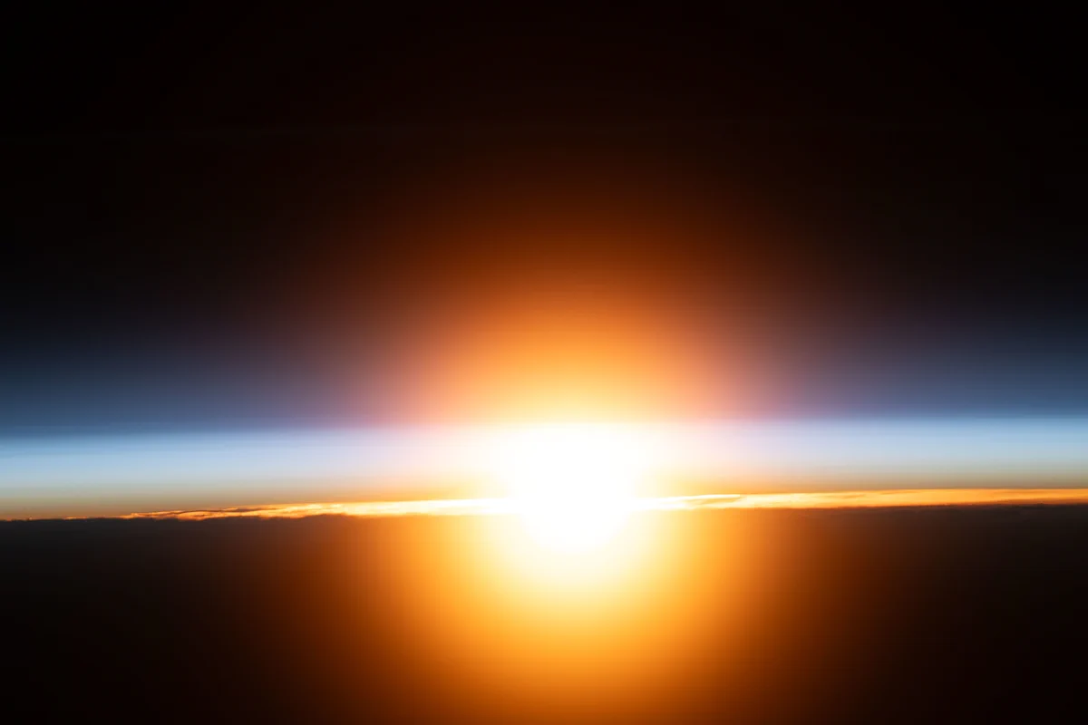 A bright orange sunburst illuminates Earth's atmosphere during an orbital sunrise in this photograph from the International Space Station as it orbited 265 miles above western Mongolia.