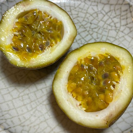 matun_matun's tweet photo. 先日家で育てているパッションフルーツ第１号を食べました。熟していないのに落ちてしまった緑色の実を保管して少し追熟させたもの。グレープフルーツのような酸味で甘さは足りないけれど、最後はちみつをかけたら丁度良い味に。次は完熟紫色の実を期待しつつ、初味見、楽しかったです。 https://t.co/PmT3bliwIk