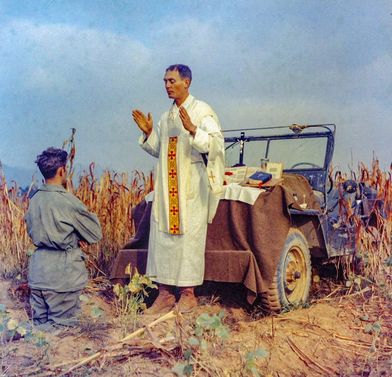 ForgottenWarPic's tweet photo. The bravest man in the prison camp did not carry a rifle. He carried a Mass kit and a stolen sack of food, and the Communists were more afraid of him than of any soldier there.

Father Emil Kapaun was a Catholic priest from a tiny farm town in Kansas. Soft spoken, humble, the kind of man who probably should have spent his life doing quiet parish work. Instead he put on an Army uniform and became a chaplain, and he ended up on the front line in Korea in the fall of 1950.

At the battle of Unsan his unit got overrun by a massive Chinese assault. Men were told to pull out and save themselves. Kapaun refused to leave. He walked back and forth through the incoming fire, unarmed, dragging wounded soldiers out of the open, giving last rites to the dying, carrying men on his back. When the position finally fell he could have slipped away. He stayed with the wounded who could not move, knowing it meant capture.

Then came the moment people never forgot. A Chinese soldier stood over a wounded American sergeant named Herbert Miller, about to execute him where he lay. Kapaun walked straight up, pushed the enemy soldier aside, picked the wounded man up off the ground, and carried him away. The enemy was so startled by the sheer nerve of it that they let it happen. Miller lived the rest of his life because a priest refused to let him be shot.

What he did in the prison camp over the next seven months might be the most incredible part. In a filthy, freezing camp where men were dying of starvation and dysentery every day, Kapaun became the heart of the place. He snuck out at night to steal food for the sick. He boiled water in secret to keep men from dying of disease. He gave away his own tiny rations. He washed the filth off dying soldiers with his own hands, and he led prayers out loud in defiance of guards who beat him for it, keeping hope alive in men who had every reason to quit.

The Communists hated him for it, because faith was the one thing they could not take from those prisoners as long as he was breathing. Eventually the beatings and the starvation and a blood clot broke his body. When he got too sick, the guards hauled him off to the death house, a filthy room where they dumped men to die alone. He forgave his guards on the way out. He died there in May 1951 at just thirty five years old.

Sixty two years later they gave him the Medal of Honor. His fellow prisoners, the ones who lived because of him, spent their whole lives telling the world what he did. His body, long lost in an unmarked grave, was finally identified and brought home in 2021. And the Catholic Church is now on the road to declaring the humble priest from Kansas a saint.