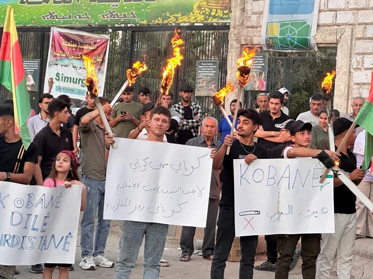 Judy20255's tweet photo. A Protest Rally by the People of Qamishlo

Under the slogan:

“Kobanê is not just a passing name; it is an identity written in blood, a name tied to the city’s history and one that deserves to be officially recognized in official documents.”

Kobanê is not Ain al-Arab…

#كوباني_ليست_عين_العرب 
#defendKobani