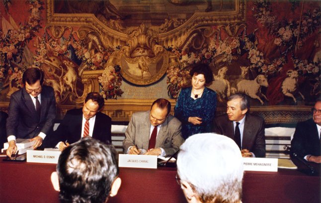 DisneyphileLIVE's tweet photo. Après de longs mois de négociations entre le gouvernement français et The Walt Disney Company, le 11 juillet 1986, la Région Île-de-France approuve les plans du projet Euro Disney Resort avec une majorité de 112 voix contre 20.

Tout ceci pour déboucher quelques mois plus tard à la signature du contrat final entre le PDG de Disney, Michael Eisner, et le Premier Ministre français Jacques Chirac, à l'Hôtel Matignon. La suite, on la connait...
