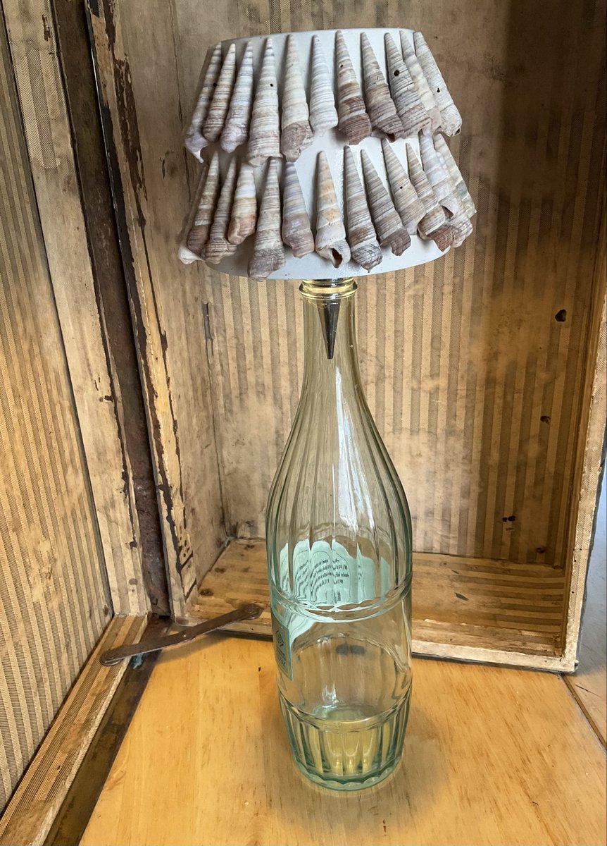 Superhuisvrouw's tweet photo. Het oplaadbaar tafellampkapje komt van Temu, is redelijk saai. Als attentie voor vriendin die echt strandliefhebber is, kreeg het kapje een make-over. Spuitverf en penhoorntjes uit Zandvoort doen de rest. Kleine moeite, groot verschil #diy https://t.co/wOaoSREfit