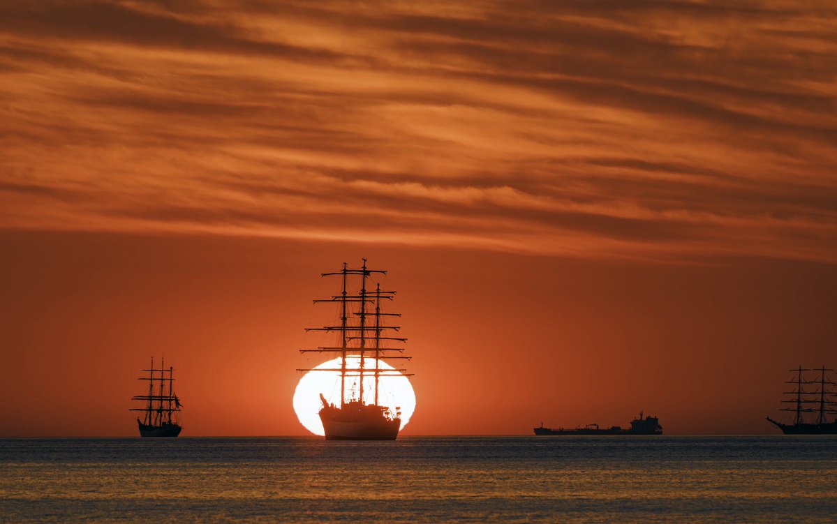 NBC10Boston's tweet photo. A Sail Boston sunrise. Tall ships participating in today’s Sail Boston extravaganza are seen with various stages of this mornings sunrise, starting with a Massachusetts state police helicopter doing a quick scan of the area and then lots of colors. 📸@pictureboston https://t.co/oG9CNonFOf