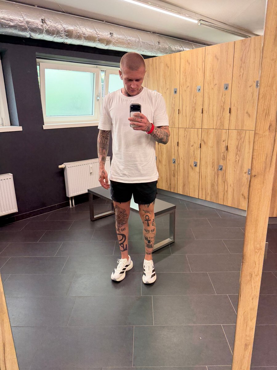 Darianblkwell's tweet photo. locker room, white tee, arms out. simple day, loud sleeves. https://t.co/Pb8wh8vMXa