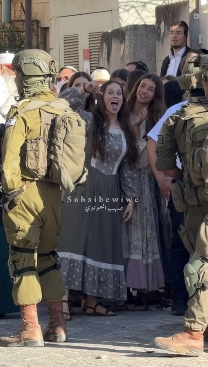 MosabAbuToha's tweet photo. Thumbs down and tongue out.
An israeli settler mocks the Indigenous Palestinian residents of al-Khalil (Hebron) as she and other settlers invade the city under the protection of terror israeli soldiers today.

Looking at her, where do you think she came from? https://t.co/AJONvyy0WY
