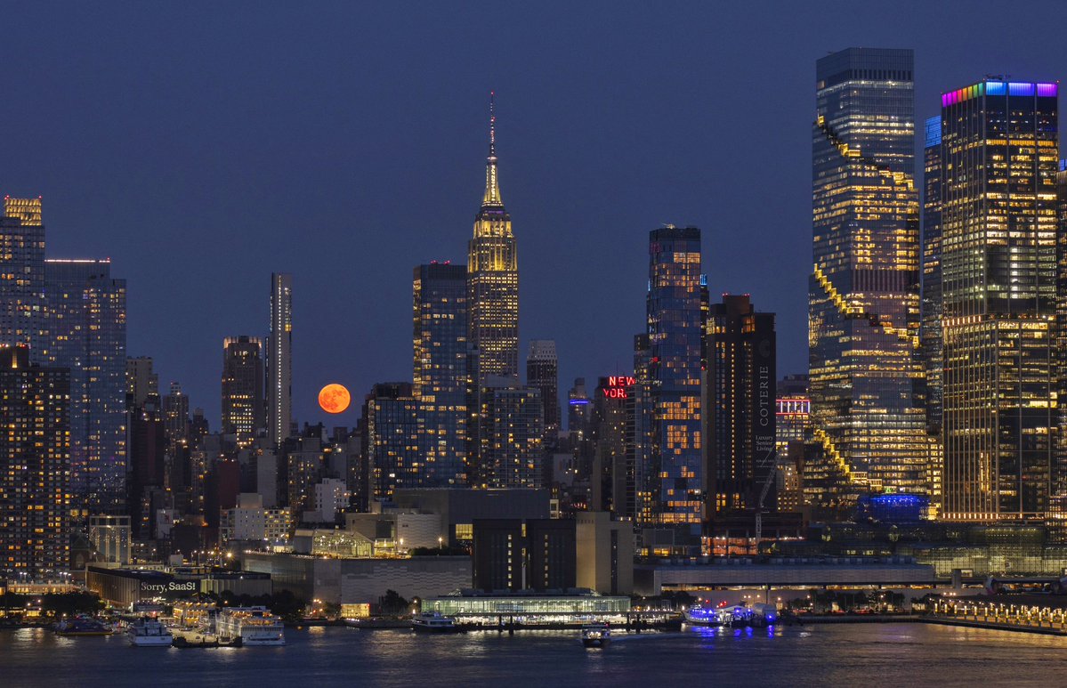GaryHershorn's tweet photo. The full Strawberry Moon rises behind the skyline of midtown Manhattan and the Empire State Building in New York City, Monday evening #newyorkcity #nyc #newyork @empirestatebldg #moon #strawberrymoon #fullmoon https://t.co/oUJSMsvTXC