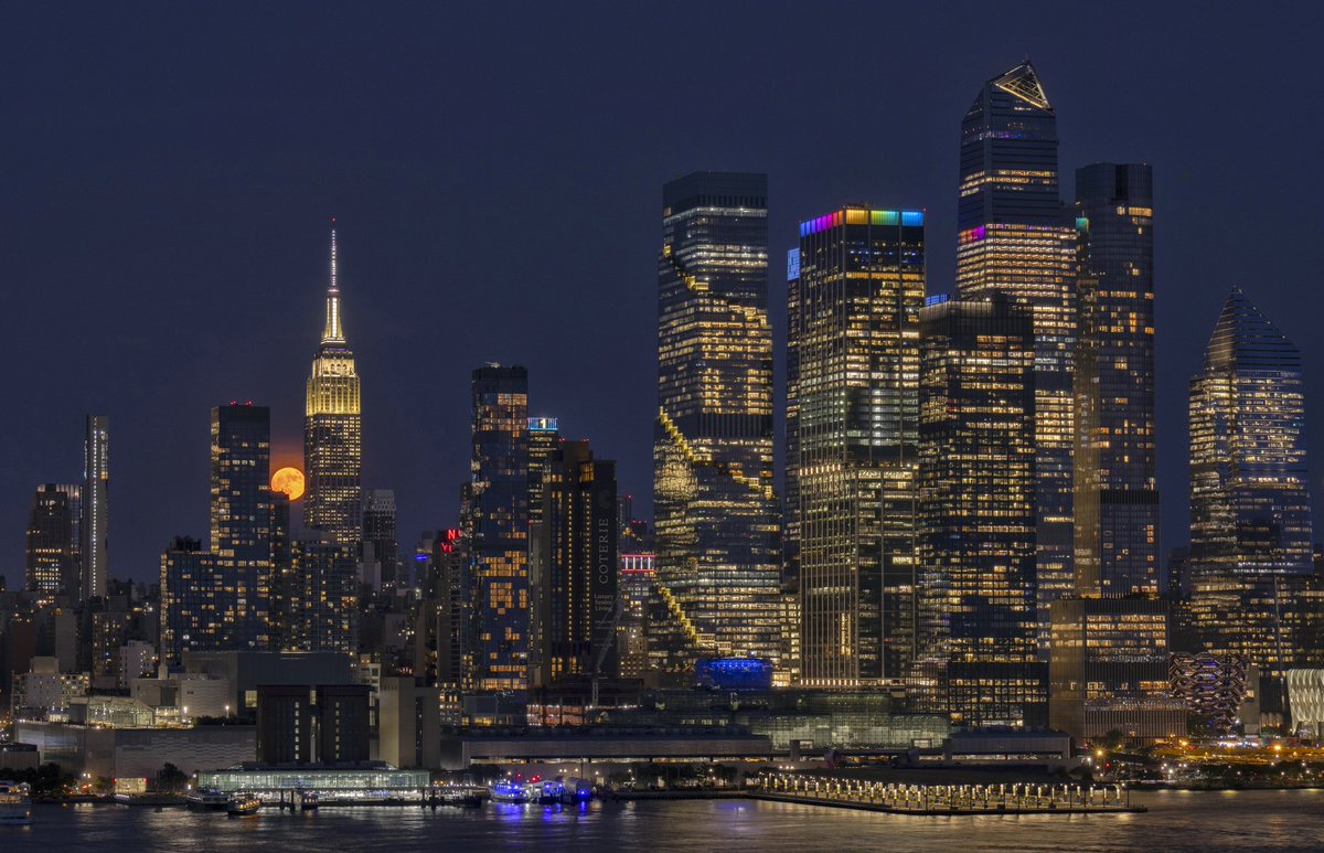 GaryHershorn's tweet photo. The full Strawberry Moon rises behind the skyline of midtown Manhattan and the Empire State Building in New York City, Monday evening #newyorkcity #nyc #newyork @empirestatebldg #moon #strawberrymoon #fullmoon https://t.co/oUJSMsvTXC