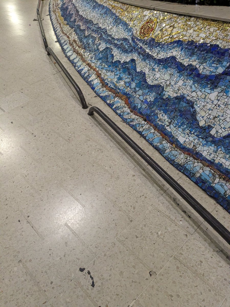rob_milky's tweet photo. The dark, low-lying floor rails at Glasgow Central are an absolute trap for blind and partially sighted walkers! A long cane sweeps right under them without warning (see file 1000048748.jpg). Total trip hazard. Remove or replace them now @NetworkRail! https://t.co/yhdBeKrctT https://t.co/f0gwxja5gY