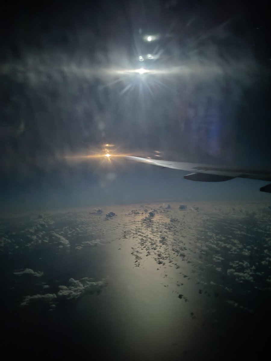 飛行機から 月が明るくて夜でも海が明るく照らされており物理的な感覚