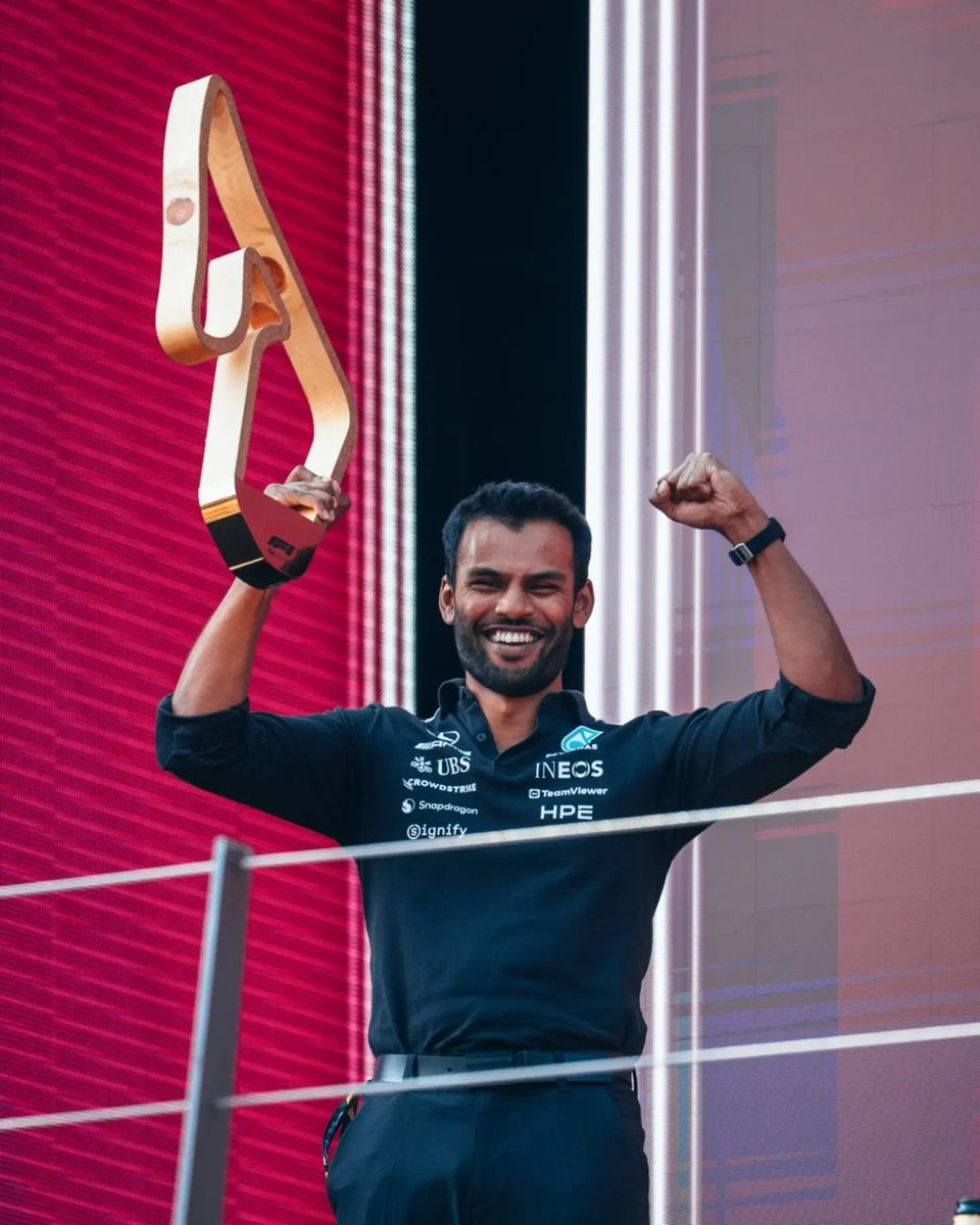 TamilGuardian's tweet photo. 💫 British Tamil engineer takes F1 podium spotlight after Mercedes win

British Tamil engineer Arun Rajkumar became an unexpected face of Mercedes’ Austrian Grand Prix celebrations after stepping onto the Formula 1 podium and lifting the race-winning constructors’ trophy for the team.

Rajkumar, who was born into an Eelam Tamil family, is a trackside power unit engineer for Mercedes AMG High Performance Powertrains, the Brixworth-based division that designs, manufactures and tests Formula 1 power units for Mercedes and its customer teams.