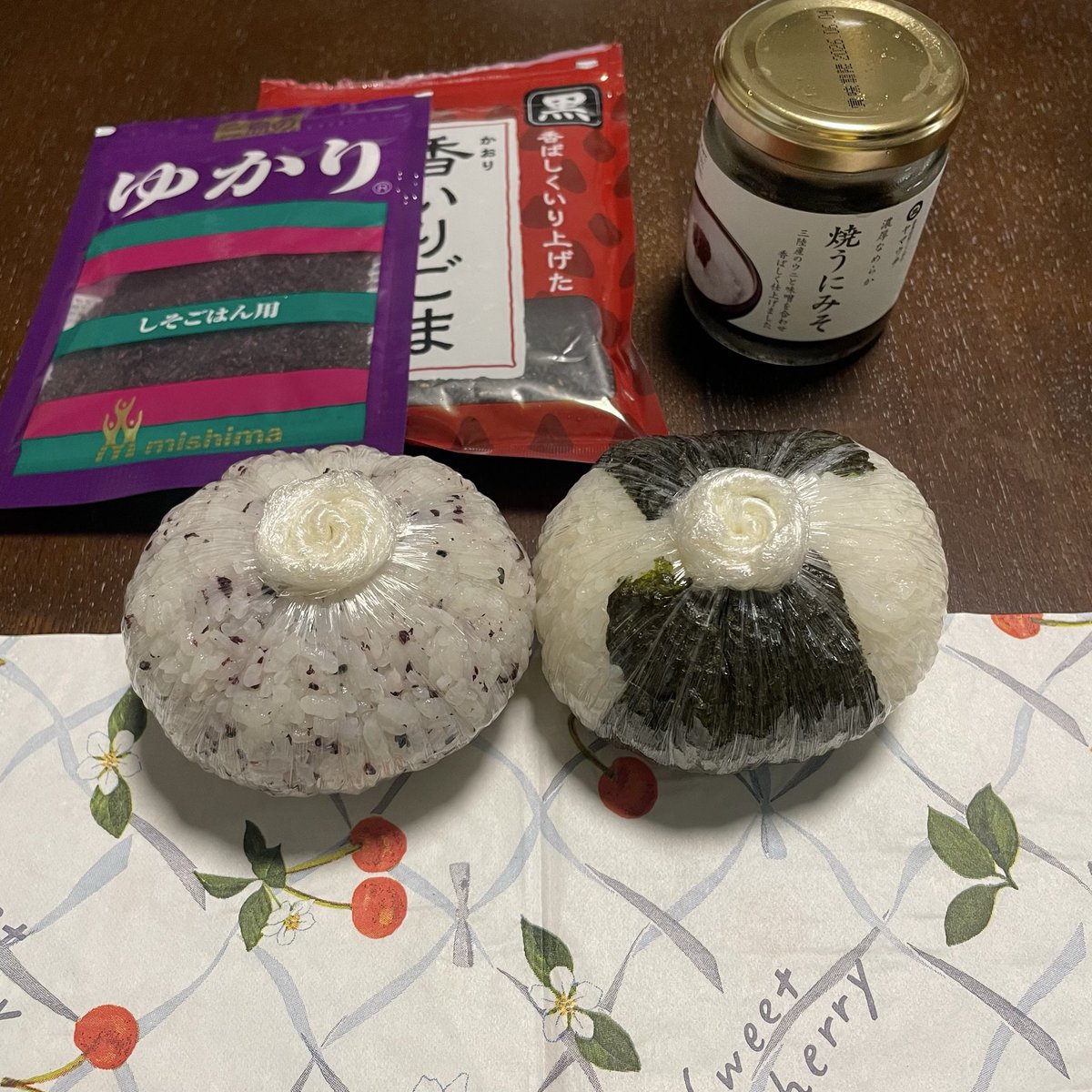 uda1972's tweet photo. 今日の朝おむすびは、ゆかり＋黒炒りごまの混ぜごはんに焼きうにみそ🍙
ペーパーナプキンは、スイートチェリー🍒
本日の天気は、曇り☁️気温は昨日とほぼ同じ予報。
上期下期の諸々が引き続き大事なく乗り切れますようにと祈りつつ…
今日も1日ご安全に🙏 https://t.co/RlNmZTZfQA