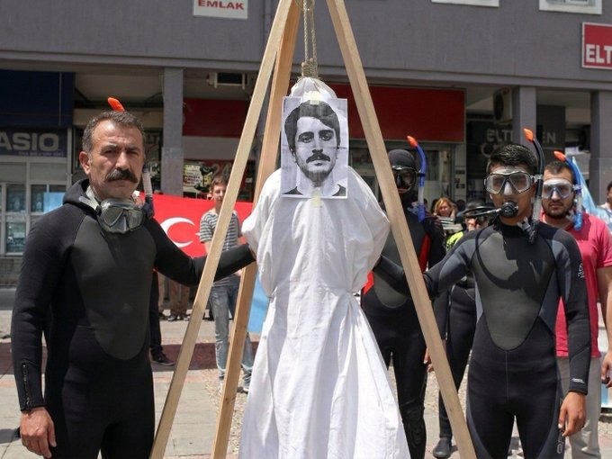 serhatayan's tweet photo. Dalgıçlar Deniz'i gıyabında asıyorlar. Çünkü onun "s..min dalgıçları" demesinden derin bir üzüntü duymuşlar (Evet bizim ülkemizde üzülen insanlar üzenleri asarlar)

Ben size konteksti hatırlatayım: Adam tatile gittiğini söylüyor. Denizden çıkan bütün vücutları simsiyah kıyafetle örtülü başları kapalı birilerini gördüğünü ve çok rahatsız olduğunu söylüyor.
Seyirci o anda inanılmaz geriliyor: Lan bu adam başı kapalı ve haşemayla denize gidenlere laf mı edecek diye. Öyle biri gibi durmuyor çünkü... Ve o anda bunların dalgıç olduğunu söyleyerek insanların bu beklentiye girmiş olmasını da eleştiren; aynı zamanda izleyen milyonlarca kişiyi ters köşeye yatıran bir zeka oyunu yapıyor. Seyirci gösterinin en hacimli kahkahasını atıyor. 

Bu fikri derinlik içinde bizimkilerin derdi: Kimse dalgıç s..kemez...