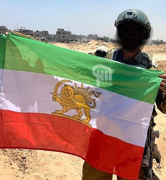 Matthew73610025's tweet photo. An IDF soldier raising the Lion and the Sun flag.

Israel stands with the Iranian people. https://t.co/pkR7HAUICG